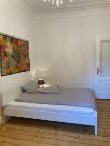 1 cama en una habitación blanca con un cuadro en la pared en 3 Zimmer-Lounge in KÖLN Sülz mit Küche, Balkon, 2 Bäder, en Colonia