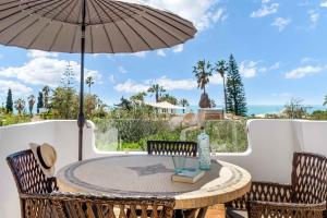 a patio with a table and chairs and an umbrella at Casa Adélia in Carvoeiro
