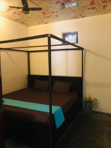 1 dormitorio con cama con dosel en una habitación en FS Hotel & villa en Arugam Bay
