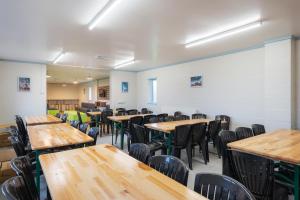 une salle de classe vide avec des tables et des chaises en bois dans l'établissement Stunning Rural 72 bed bunkhouse 21 Bedrooms, à Elerch