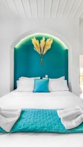 a bed with a blue headboard with feathers on it at Lady Stamatias House in Halki