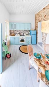 a kitchen with blue cabinets and a table at Lady Stamatias House in Halki