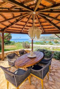 a wooden table and chairs under a wooden umbrella at Lady Stamatias House in Halki