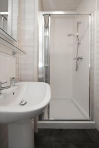 a white bathroom with a sink and a shower at Burgie Woodland Lodges in Forres
