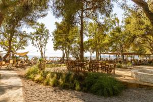 a park with tables and chairs and trees at Ergon Beach House Nikiti in Nikiti