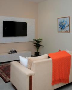 uma sala de estar com um sofá e uma televisão de ecrã plano em Luxe Living Mbuya em Kampala