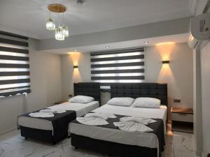 two beds in a room with windows and lights at Olive Hotel in Pamukkale