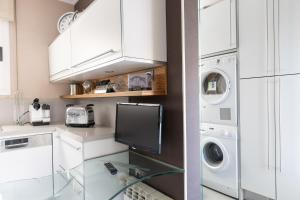 a kitchen with white cabinets and a washer and dryer at Stay Barcelona Long Term Camp Nou in Barcelona