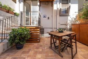 d'une terrasse avec une table et des chaises en bois sur un balcon. dans l'établissement House Roberta - Green Oasis in the City, à Cagliari