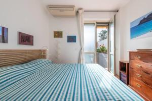 - une chambre avec un lit doté d'un couvre-lit rayé bleu et blanc dans l'établissement House Roberta - Green Oasis in the City, à Cagliari