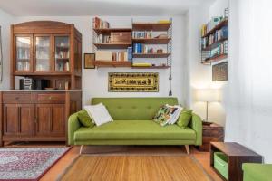 - un canapé vert dans le salon avec une étagère dans l'établissement House Roberta - Green Oasis in the City, à Cagliari