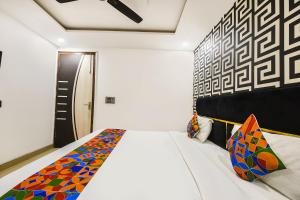 a bedroom with a white bed with a colorful blanket at FabHotel The Royal Residency in New Delhi