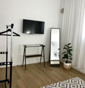um quarto com um espelho, uma mesa e uma televisão em Nika's Guest House em Berat