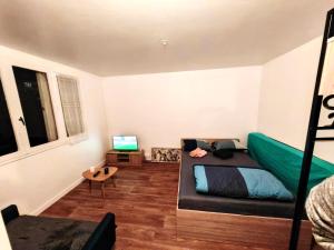 een slaapkamer met een bed en een bureau met een laptop bij F1 équipé avec ascenseur, parking et près des transports in Argenteuil