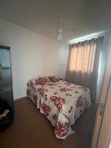 een slaapkamer met een bed met een rode en witte deken bij Apartamento aconchegante em Betim in Betim