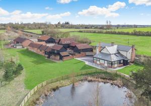 una vista aérea de una casa con un estanque en White House Lodges - Dragonfly en Heveningham