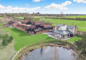 an aerial view of a house with a pond at White House Lodges - Meadow in Heveningham