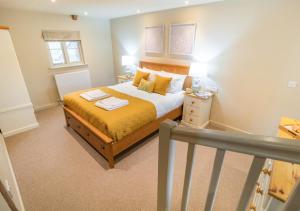 1 dormitorio con 1 cama con sábanas amarillas y almohadas amarillas en White House Lodges - Dragonfly en Heveningham