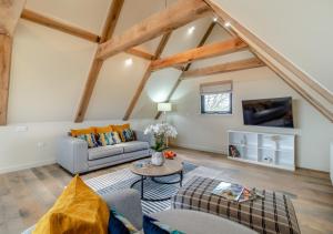 uma sala de estar com um sofá e uma mesa em White House Lodges - Wagtail em Heveningham