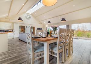 uma cozinha e sala de jantar com uma mesa de madeira e cadeiras em White House Lodges - Napier em Heveningham