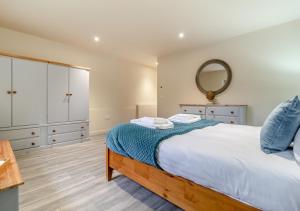 um quarto com uma cama grande e um espelho em White House Lodges - Wagtail em Heveningham