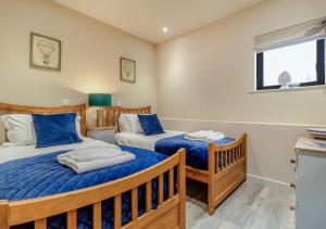 um quarto com 2 camas e uma janela em White House Lodges - Nightingale em Heveningham