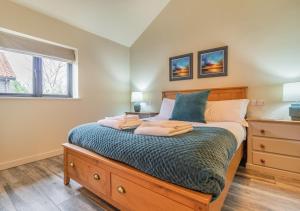 um quarto com uma cama com uma cómoda e uma janela em White House Lodges - Napier em Heveningham