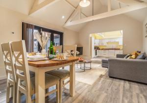 a dining room and living room with a table and chairs at White House Lodges - Tawny in Heveningham