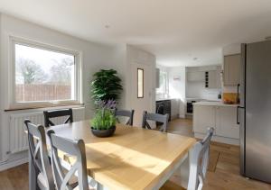 a kitchen and dining room with a wooden table with a potted plant at Cherry Trees - Acton in Waldingfield