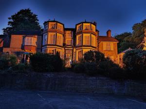 a large house is lit up at night at The Chantry hotel in Dronfield