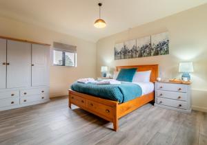 a bedroom with a bed and a dresser at White House Lodges - Avocet in Heveningham