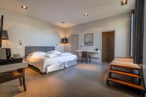 a bedroom with a bed and a desk and a table at Lafitenia Resort in Saint-Jean-de-Luz