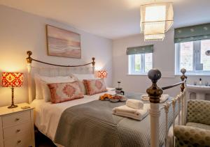 1 dormitorio con 1 cama, 1 silla y ventanas en Orford Cottage en Aldeburgh