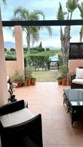 un patio con sillas y mesas y vistas al agua en Thistle 2.0b, en Murcia