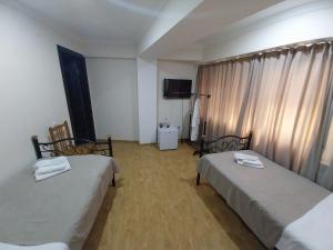 a room with two beds and a television in it at Magnolia in Kutaisi