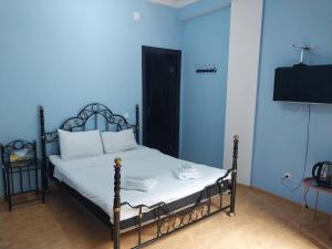 a blue bedroom with a bed with a black frame at Magnolia in Kutaisi
