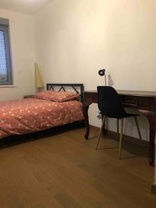 een slaapkamer met een bureau en een bed en een bureau bij Les Cotonnades (Colmar) in Wintzenheim