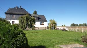 uma casa com um quintal com um campo de futebol em Monteurzimmer Alte Schule Heberndorf 1 em Wurzbach