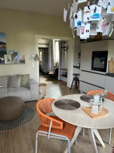 een woonkamer met een tafel en stoelen en een bank bij Cues11 in Bernkastel-Kues