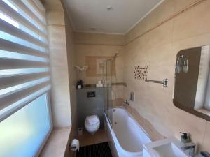 a bathroom with a tub and a toilet and a sink at Kamieniec No5 Apartments in Zakopane +13 photos