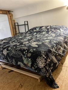 ディジョンにあるAppartements atypiques centre historiqueの黒と白の毛布が備わるドミトリールームのベッド1台分です。