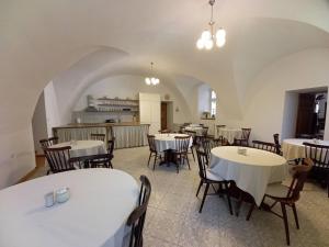 une salle à manger avec des tables et des chaises ainsi que des tables blanches dans l'établissement Penzion Zámek Rozsochatec, à Rozsochatec