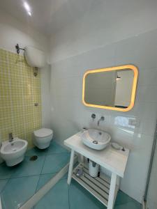 a bathroom with a sink and a toilet and a mirror at Il Sirenio in Sorrento