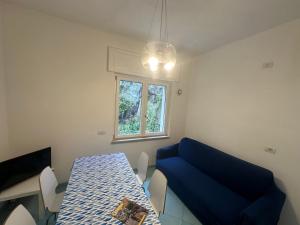 a room with a table and a blue couch at Il Sirenio in Sorrento +9 photos