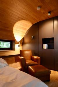 - une chambre avec un lit, une chaise et un plafond dans l'établissement K1 Baumhaus, à Odenthal