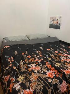 a bed with a black blanket with flowers on it at La Vie de Bohème in Trieste