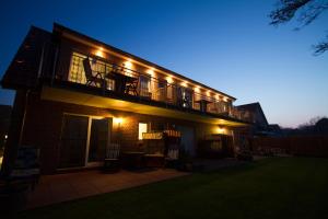 een huis met een balkon met verlichting bij Pension Haus My in Norddeich