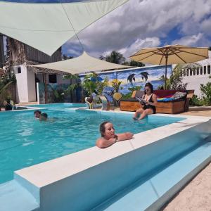 a group of people sitting in a swimming pool at TIANDE Boutique Hotel in Pwani Mchangani