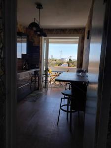 eine Küche und ein Esszimmer mit einem Tisch und einem Fenster in der Unterkunft Apparemment vue mer in Aytré