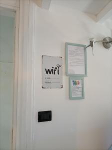 uma porta branca com um sinal que lê wi-fi nela em Maison 61 em Catânia